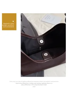 Detail view of the magnetic closure and internal zipper pocket of this brown tote bag