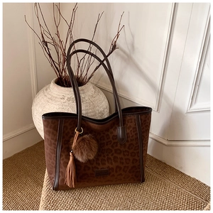 Detail of leopard print tote bag with soft texture and stylish tassel charm detail