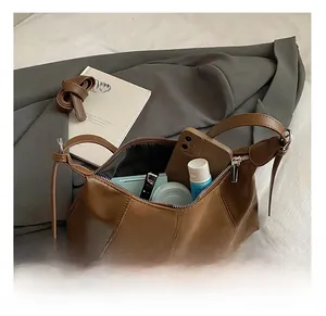 Détails de la capacité interne du sac demi-lune en similicuir marron avec accessoires