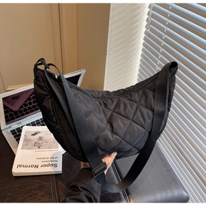 Detail of black quilted nylon hobo bag with adjustable strap and diamond stitch pattern