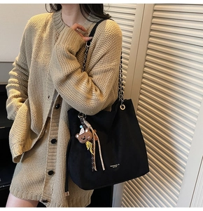 Détail du sac cabas noir avec bandoulière en chaîne dorée et petit ours en peluche