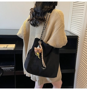 Détail du sac cabas noir avec bandoulière en chaîne et pendentif ours brun mignon
