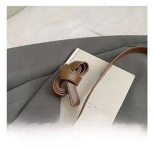 Détail de la bandoulière réglable en cuir marron avec boucle argentée et coutures renforcées