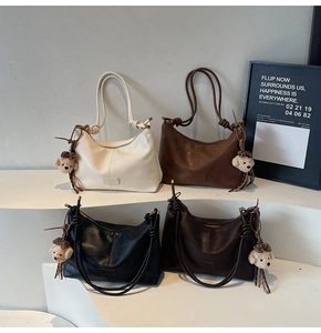 Detailed display of four textured tote bags in white, black, and brown with bear charms