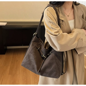 Close-up of a large vintage coffee brown suede tote bag with metallic buckle detail