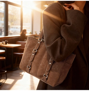Detail of vintage large brown tote bag in soft suede material with metal buckle accents