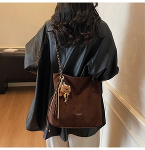 Vue détaillée du grand sac cabas marron en daim avec bandoulière chaîne et bijou d'ours