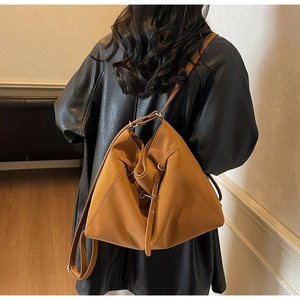 Brown leather tote bag shown on model highlighting large capacity and soft texture