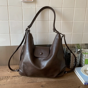 Detail view of deep brown hobo bag with textured leather surface and stylish buckle closure
