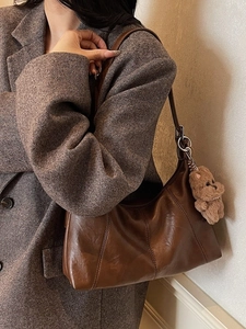 Retro dark brown underarm bag in polished leather with a cute plush bear charm