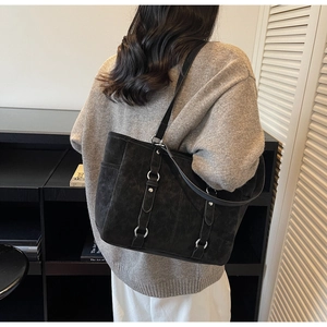 Close-up of black matte tote bag with silver metal ring buckles and minimalist design
