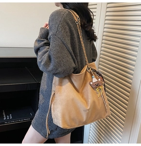 Détail du grand sac cabas en daim camel avec bandoulière chaîne et pendentif ours