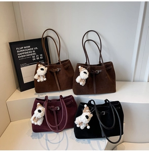 Dettaglio di borse tote in camoscio in vari colori con graziosi ciondoli in peluche