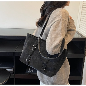 Close-up of black retro tote bag with silver hardware buckles and premium matte texture