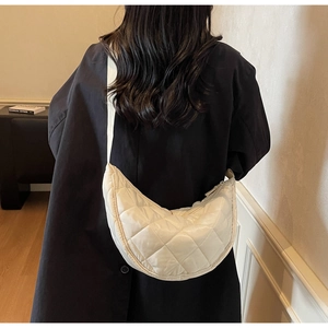 Detail of white quilted nylon crescent bag featuring elegant diamond stitching and strap