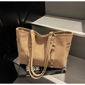 Detail of khaki tote bag showing luxury synthetic leather texture and metal buckles