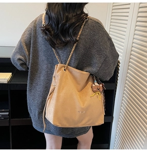Détail du sac cabas en daim camel avec bandoulière chaîne et pendentif ours
