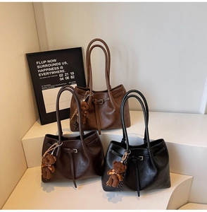 Detailed view of three vintage pleated tote bags in brown, coffee, and black with teddy charms