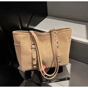 Detail of khaki tote bag featuring vertical stitching and functional side pockets for work