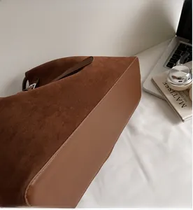 Dettaglio della borsa tote in pelle scamosciata marrone con rifiniture in pelle lucida