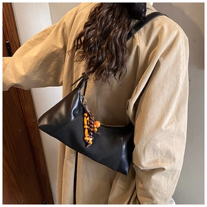 Détail du sac sous le bras vintage noir avec pendentif unique en perles colorées