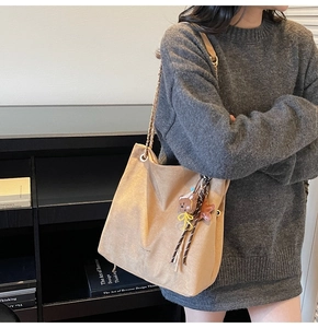 Détail du grand sac cabas en daim beige avec charm ours en peluche et chaîne dorée