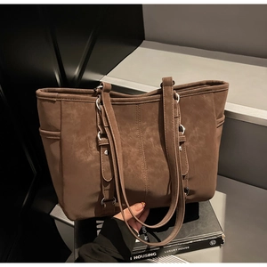 Close-up of vintage brown tote bag with silver hardware and retro matte leather texture