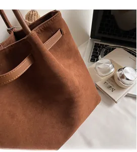 Vista dettagliata della borsa tote in pelle scamosciata marrone con accessori da ufficio