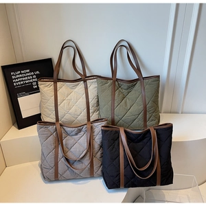 Detailed display of quilted tote bags in beige, green, gray and black colors