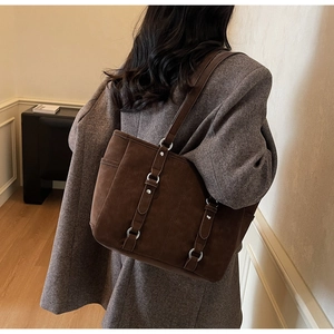 Detail of dark brown vintage tote bag showing matte texture and silver metal ring accents