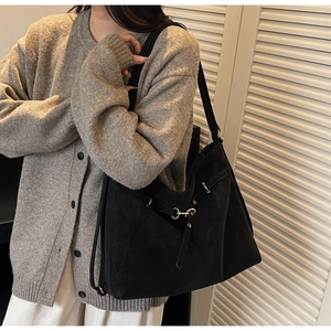 Detail of a large black vintage tote bag showing its matte texture and golden buckle