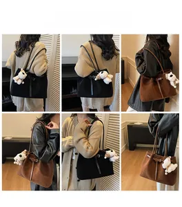 Dettaglio delle grandi borse tote opache nei colori nero e marrone con ciondolo peluche