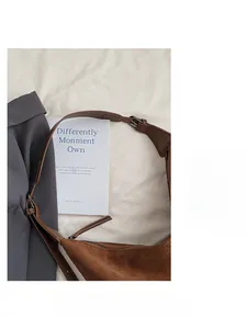 Detail of adjustable leather strap and brown suede texture on vintage shoulder bag