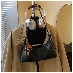 Détail du sac à bandoulière en cuir synthétique noir avec pompon en perles de bois rétro