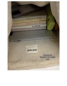 Spacious interior of white fleece tote bag showing laptop, books, and phone capacity