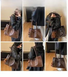 Brown vintage pleated tote bag on model's shoulder showing large capacity and bear charm