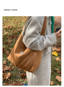 Outdoor model show of a large caramel suede tote bag with white furry lining and side label
