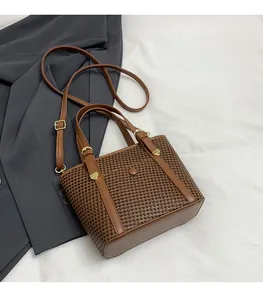 Dettaglio di borsa tote vintage in tessuto pied-de-poule e manici in pelle