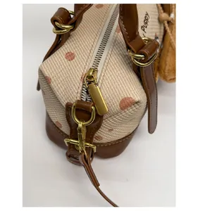 Détail du zip doré et des ferrures sur le sac à main Boston à pois élégant