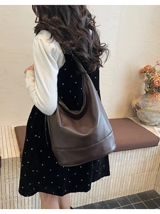 Detail view of large brown faux leather hobo bag showing spacious capacity and drape