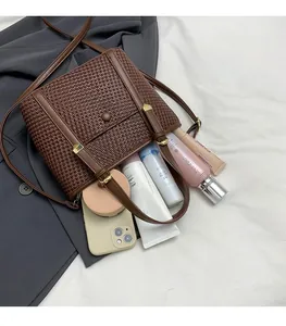 Dettaglio dell'interno della borsa tote intrecciata marrone con ampio spazio per il trucco