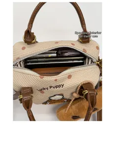 Vue de l'intérieur du sac Boston avec broderie Lucky Puppy et breloque en peluche