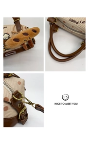 Détails du sac Boston en toile avec broderie de chien, finitions cuir et breloque