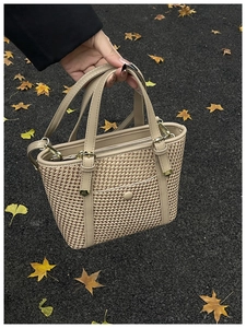 Vista dettagliata della borsa a secchiello intrecciata beige con finiture in pelle