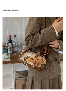 Détail de broderie chiot cartoon sur sac Boston beige et cuir marron avec charme pain
