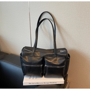 Close-up of black retro motorcycle tote bag featuring dual front zipper pockets and silver hardware