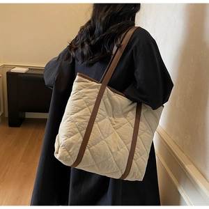 Quilted tote bag detail showing beige nylon diamond texture and brown straps for daily use