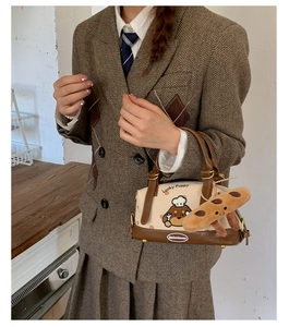 Détail du sac Boston avec imprimé Lucky Puppy et breloque en peluche de pain