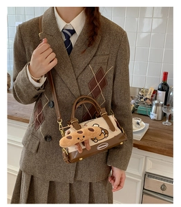 Détail du sac Boston en toile avec imprimé Lucky Puppy et breloque saucisse