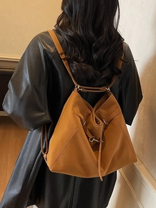 Large caramel leather bucket shoulder bag with vintage style shown on model back